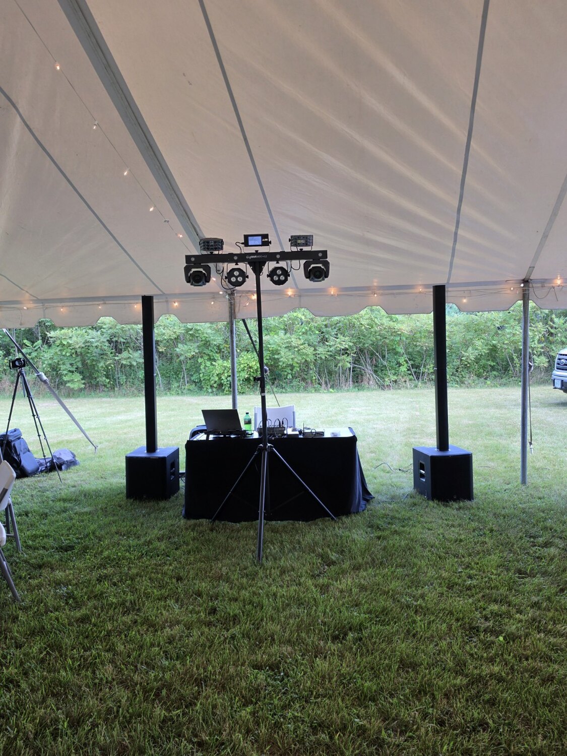 Compact DJ and lighting setup beneath an outdoor tent