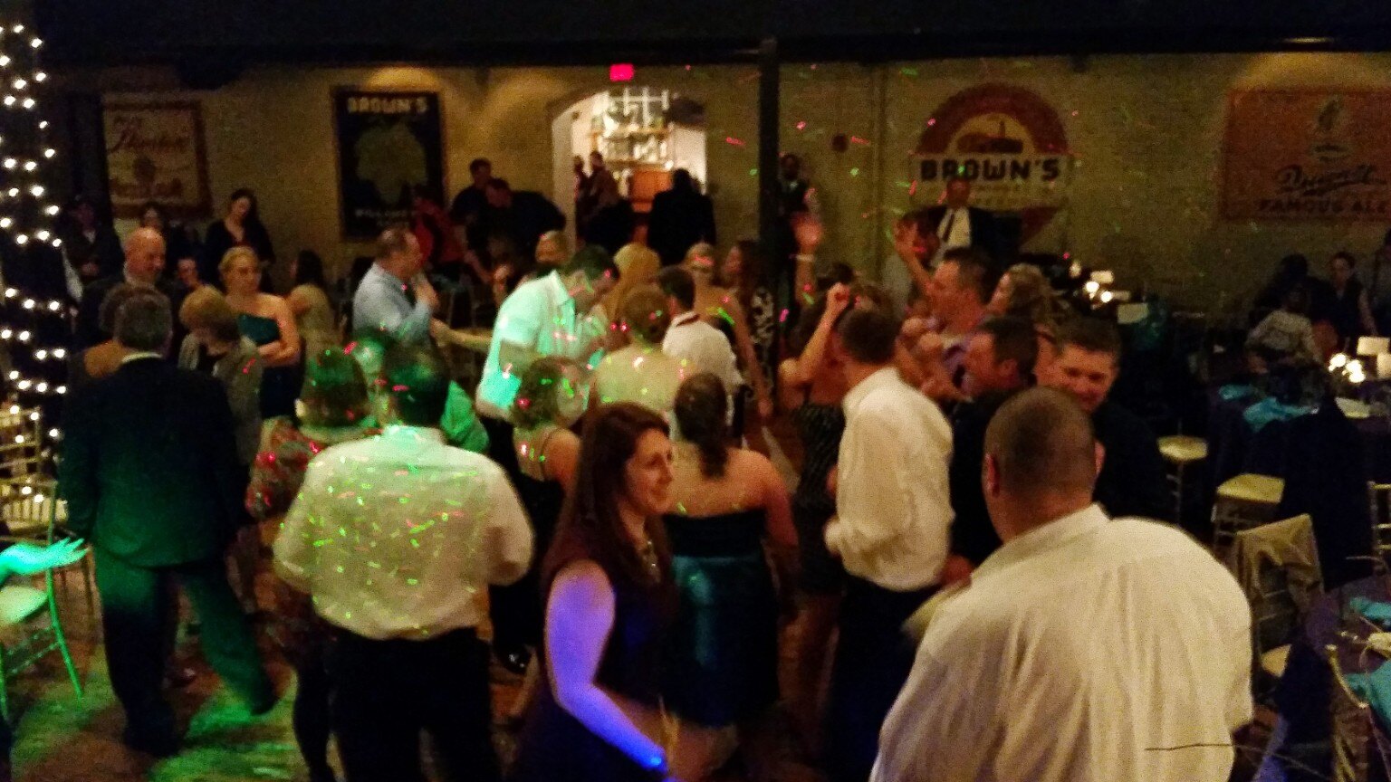 A busy reception dance floor inside a rustic venue
