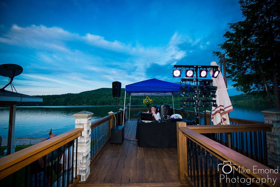 M-n-M Entertainment DJ setup overlooking a lake at an outdoor event